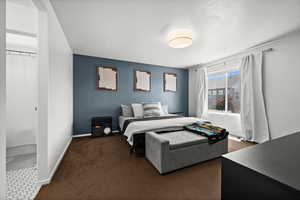 Bedroom with dark colored carpet and baseboards