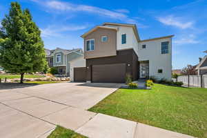 View of front of home featuring concrete driveway, an attached garage, and stucco siding