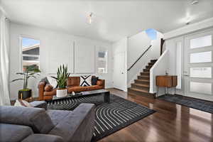 Living room featuring stairs and wood finished floors
