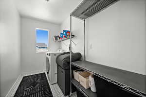 Washroom with washer and dryer and baseboards