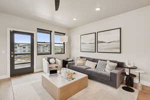 Living room featuring light wood finished floors, a ceiling fan, and recessed lighting