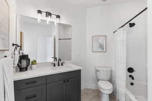 Bathroom with vanity, shower / tub combo, and tile patterned floors
