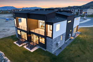 Rear view of house with roof with shingles, a mountain view, and a balcony