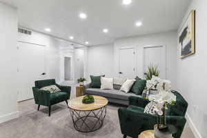 Living room featuring light colored carpet, baseboards, and recessed lighting
