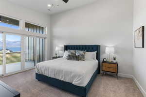 Bedroom with access to outside, carpet, a water view, and baseboards