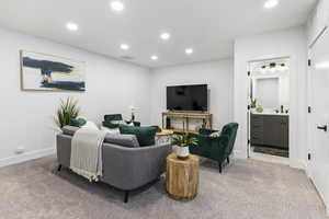 Carpeted living room with recessed lighting and bar area
