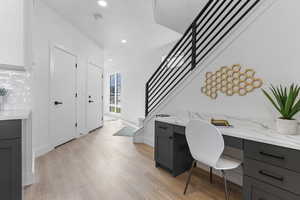 Office featuring built in study area, light wood finished floors, and recessed lighting