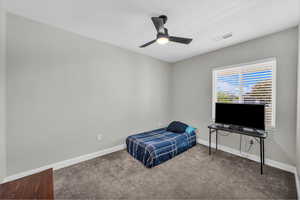 Carpeted bedroom featuring baseboards and ceiling fan