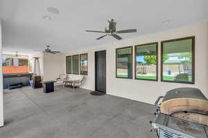 View of patio / terrace with a hot tub, a ceiling fan, a grill, and outdoor lounge area