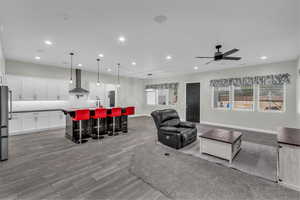 Living area with recessed lighting, plenty of natural light, light wood-style floors, and a ceiling fan