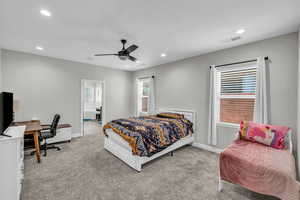 Carpeted bedroom featuring an office area, multiple windows, recessed lighting, and ceiling fan