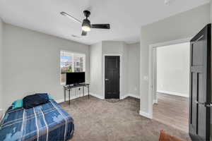 Carpeted bedroom featuring baseboards and ceiling fan