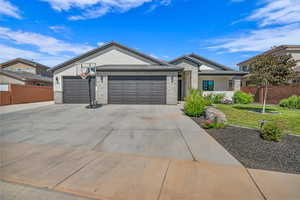 Ranch-style house featuring an attached garage, concrete driveway, brick siding, and stucco siding