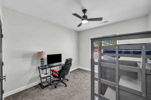 Bedroom with carpet floors, a desk, and a ceiling fan