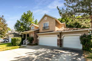 Traditional-style house featuring driveway, stucco siding, brick siding, and 3 car garage