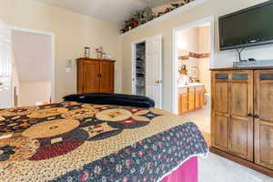 Primary bedroom featuring ensuite bath and a walk in closet