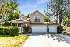 View of front of property featuring concrete driveway, stucco siding, an attached 3 car garage, shingled roof, and front lawn