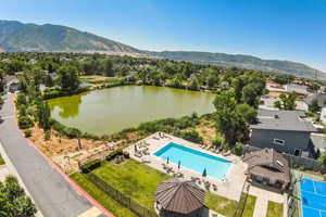 Drone / aerial view of private pond, community pool, sport court and mountain view