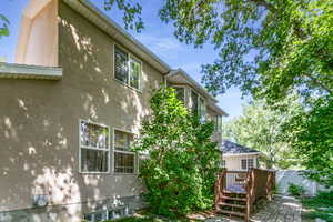 View of side of home featuring stucco siding and deck