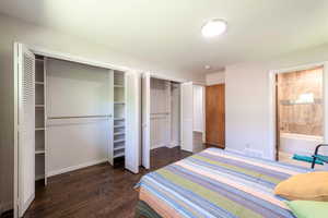 Bedroom featuring wood finished floors, multiple closets, and ensuite bathroom