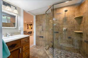 Bathroom featuring a stall shower, vanity, and recessed lighting