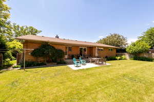 Back of property featuring brick a patio area for dining and entertaining.
