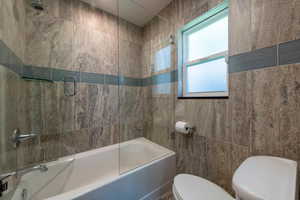 Full bath featuring shower / bath combination with glass door and tile walls.  Heated floors.