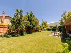 Fenced backyard featuring a patio area, an outdoor hangout area, and a mountain view
