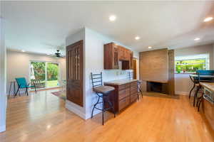 Kitchen featuring plenty of natural light,  custom cabinets, light wood finished floors, and recessed lighting