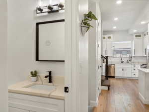 Full bath featuring recessed lighting, hardwood / wood-style floors, and two vanities