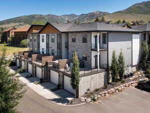 View of front facade featuring a balcony, a mountain view, and roof with shingles