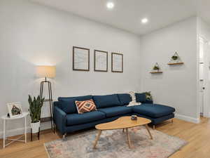 Living area with light wood-style flooring and recessed lighting