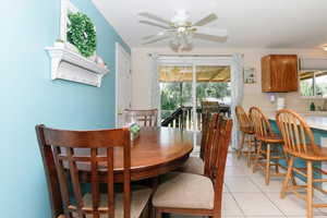 Dining area with ceiling fan and light tile patterned flooring