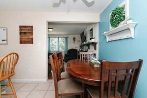 Dining space featuring ceiling fan and light tile patterned flooring