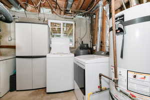 Laundry area with strapped water heater and separate washer and dryer