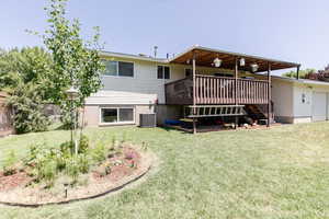 Rear view of property with stairs, a deck, and an attached garage