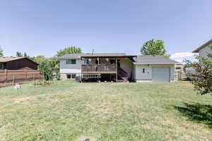 Back of house with a wooden deck, an attached garage, and stairs