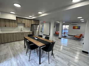 Dining area with an AC wall unit and baseboards