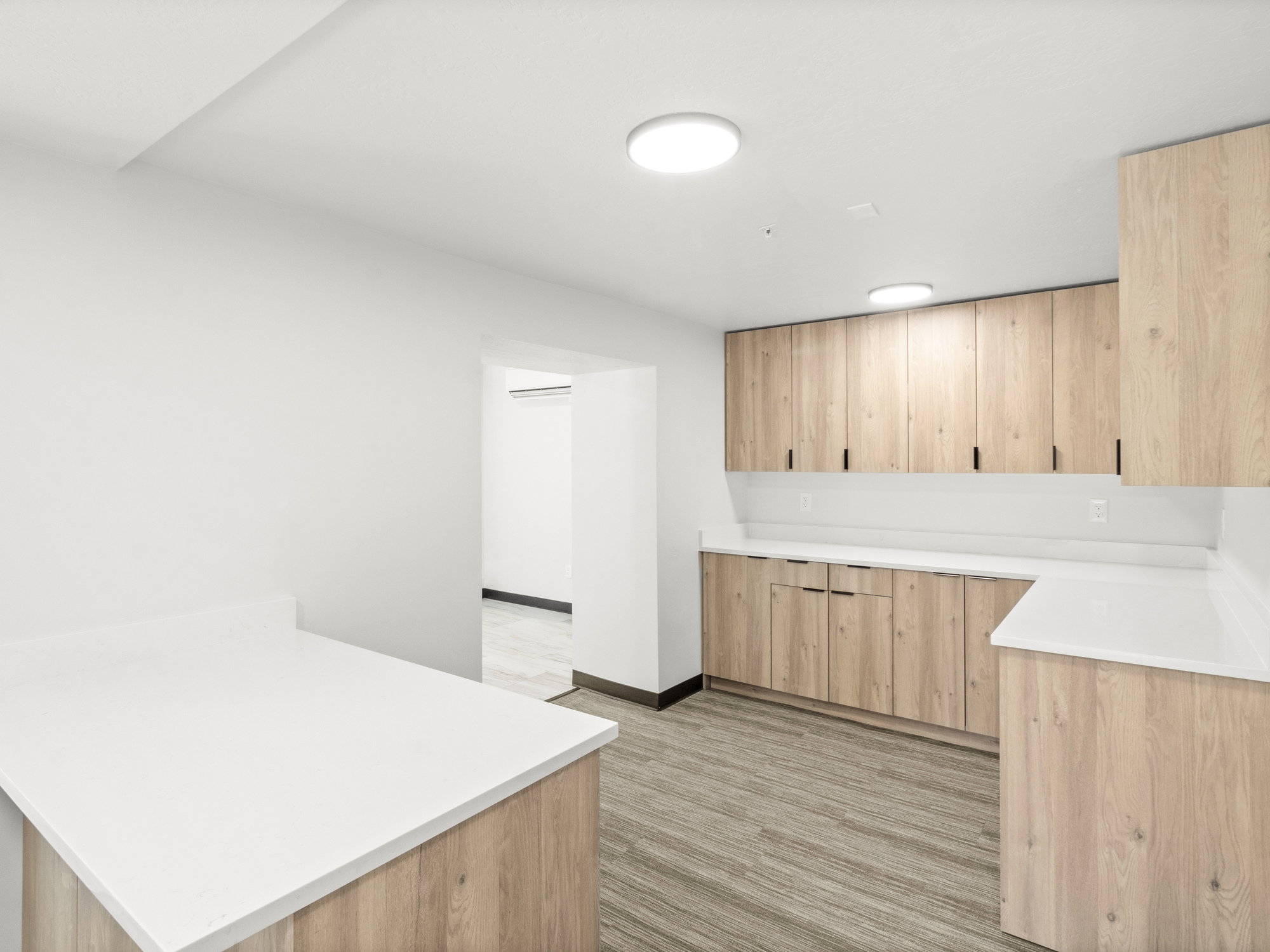 Kitchen with light brown cabinets, a peninsula, and light countertops