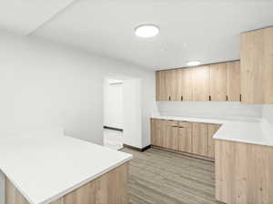 Kitchen with light brown cabinets, a peninsula, and light countertops