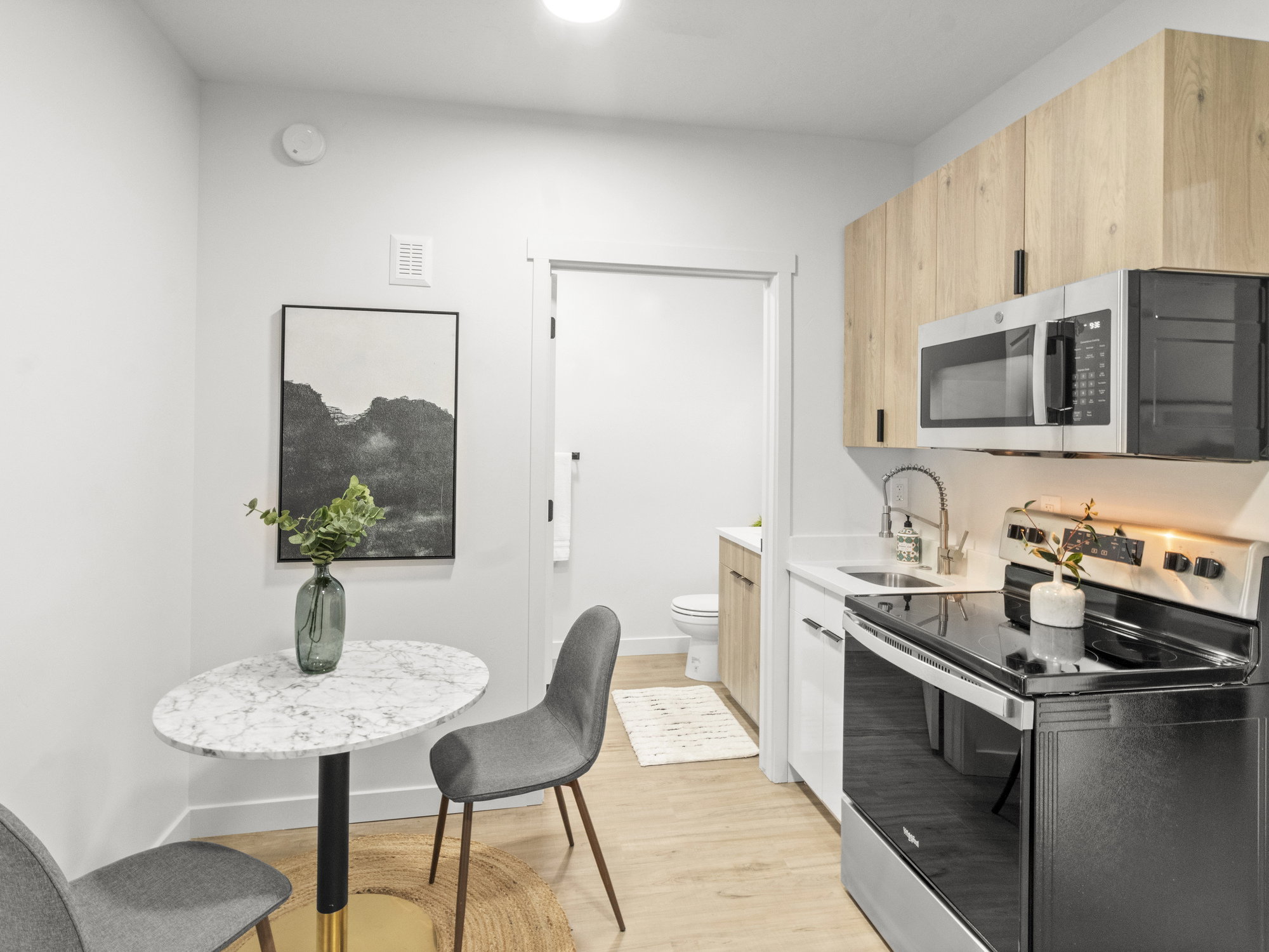 Kitchen featuring appliances with stainless steel finishes, light brown cabinetry, light wood-style flooring, and light countertops