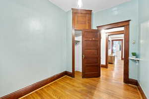 Unfurnished bedroom featuring light wood-style flooring and baseboards