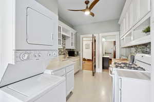 Washroom with estacked washer and dryer and ceiling fan