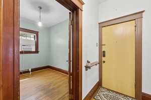 Foyer with wood finished floors and cooling unit