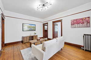 Living room featuring wood finished floors and radiator heating unit