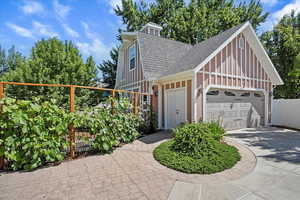View of front facade featuring roof with shingles, concrete driveway, board and batten siding, and an attached garage