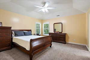Bedroom with light colored carpet, vaulted ceiling, and a ceiling fan