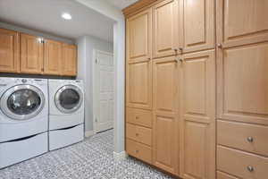 Washroom featuring washer and dryer, cabinet space, light tile patterned flooring, and recessed lighting