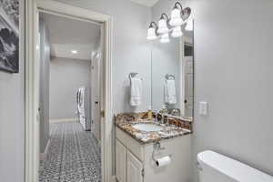 Bathroom featuring vanity, tile patterned floors, washing machine and clothes dryer, and recessed lighting