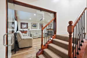 Staircase featuring wood finished floors and recessed lighting